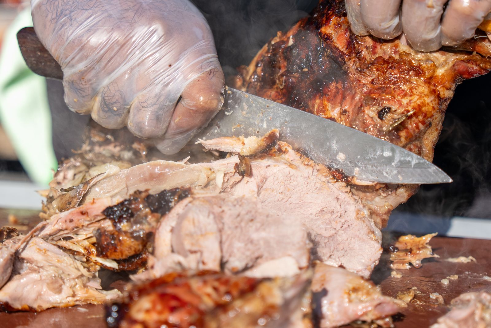 Carving slow-roasted pork, steam rising off the board
